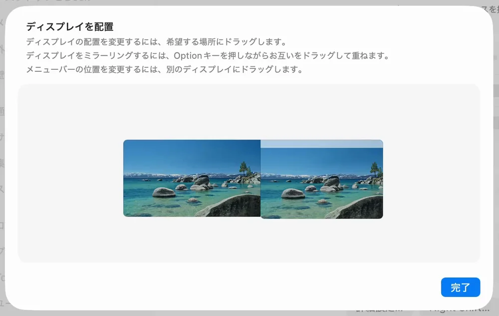 「ディスプレイを配置」の画面。説明の文が3行あり、その下に2台の画面の絵が横に並んでいる。左が大きい外部ディスプレイの絵、右が小さい内蔵ディスプレイの絵